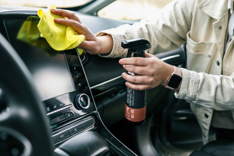 Mand som udfører indvendig rengøring af en bil, til klargøring af bilen.